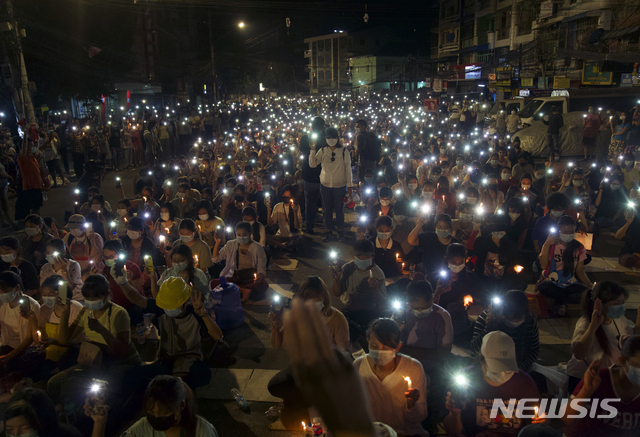 [양곤=AP/뉴시스]14일 미얀마 양곤에서 열린 군부 쿠데타 반대 촛불집회가 열려 시위대가 휴대전화 불빛을 밝히고 있다. 미얀마 군정이 양곤의 두 곳에 계엄령을 선포하고 유혈 진압을 이어가면서 이날만 최소 38명이 숨졌다고 외신들이 보도했다. 2021.03.15.