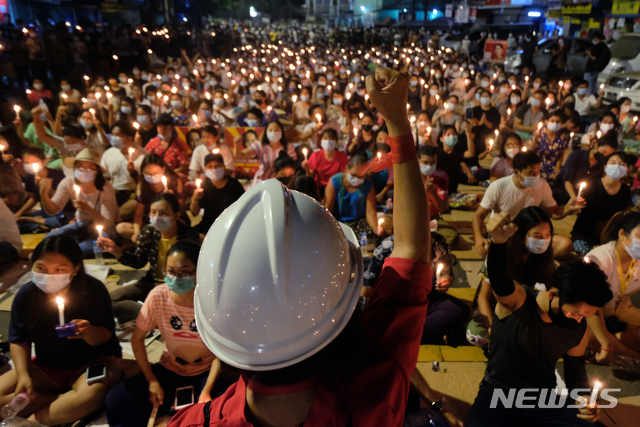 [양곤=AP/뉴시스] 지난 14일 미얀마 양곤에서 열린 군부 쿠데타 반대 촛불집회가 열려 한 시위 참가자가 군중 앞에서 주먹을 들고 있다. 2021.03.15.