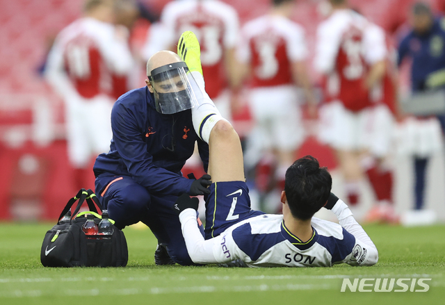 Tottenham's Son Heung-min receives medical attention during the English Premier League soccer match between Arsenal and Tottenham Hotspur at the Emirates stadium in London, England, Sunday, March 14, 2021. (Julian Finney/Pool via AP)