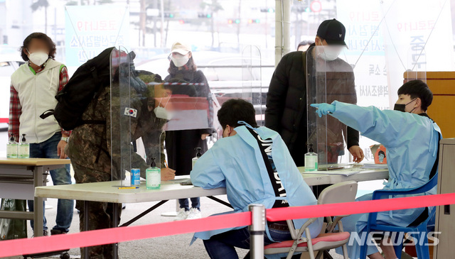 [서울=뉴시스]김병문 기자 = 코로나19 신규 확진자가 7일 만에 300명대로 감소한 지난 15일 오후 서울 용산구 서울역 앞에 마련된 임시선별검사소에서 시민들이 문진표를 작성하고 있다. 2021.03.15. dadazon@newsis.com