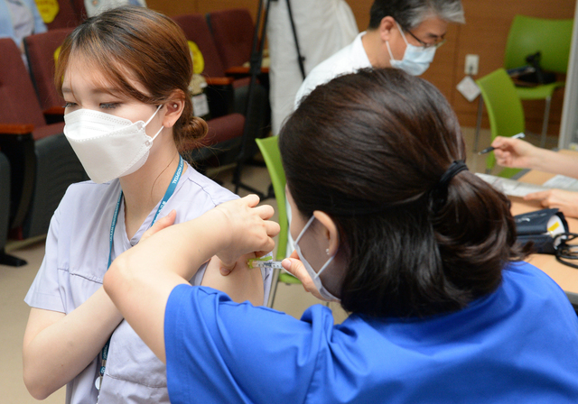 [울산=뉴시스] 배병수 기자 = 지난 3월 16일 오전 동구 울산대학교병원 음압병실 간호사 이소영(26)씨가 병원 강당에서 지역 1호로 백신을 접종받고 있다. 의료진은 코로나19 백신 우선접종 대상자였다. 2021.03.16. bbs@newsis.com