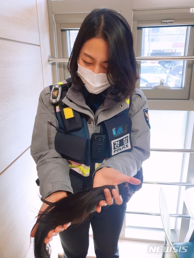 [수원=뉴시스] 이다경 순경이 기부할 머리카락을 들고 있는 모습. 