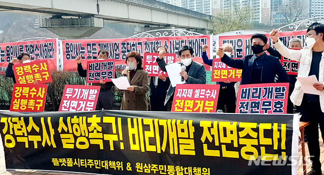 [용인=뉴시스]원삼주민통합대책위가 18일 오후 용인시청 앞 광장에서 기자회견을 열었다. 이들은 SK하이닉스 반도체 클러스터 예정지 일원에서 공직자(LH)의 투기로 의심되는 30여 건을 확보했다고 주장했다. 