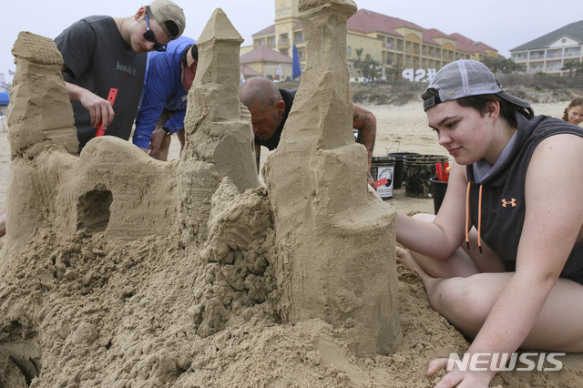 [텍사스=AP/뉴시스] 2021년 3월 모래성을 쌓고 있는 한 가족의 모습. *기사와 무관.