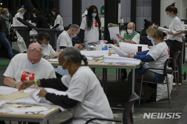 [암스테르담=AP/뉴시스] 17일(현지시간) 네덜란드 암스테르담의 한 개표소에서 흰옷을 입은 사람들이 표를 세고 있다. 코로나19의 확산을 막기 위해 네덜란드 정부는 15~17일 사흘에 걸쳐 선거를 진행했다. 암스테르담에서는 드라이브스루 투표도 펼쳐졌다. 우편투표 역시 동시에 진행됐다. 2021.03.18.