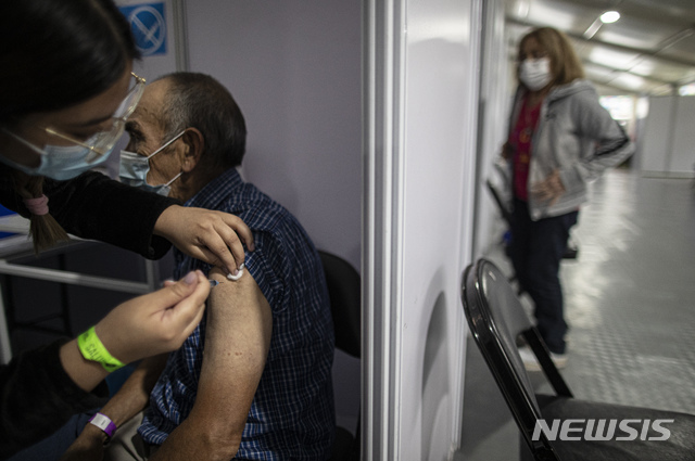 [산티아고(칠레)=AP/뉴시스]칠레 산티아고의 한 백신센터에서 지난 18일 한 남성이 코로나19 백신 2번째 접종을 받고 있다. 전 국민의 29%에게 코로나19 백신을 접종, 높은 백신 접종을 자랑하는 칠레가 광범위하고 강력한 규제 조치에도 불구, 20일(현지시간) 코로나19 시작 이후 하루 최고의 사망자 수를 기록했다. 2021.3.21