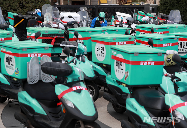 [서울=뉴시스]이영환 기자 = 지난 19일 오전 서울 송파구 우아한형제들 앞에서 열린 번쩍배달로 인한 수입감소 해결, 지방 라이더 콜 보장을 위한 배민라이더스 배달노동자 대회에서 한 배민라이더가 휴식을 취하고 있다. 2021.03.19. 20hwan@newsis.com