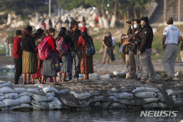 [시우다드이달고=AP/뉴시스]21일(현지시간) 멕시코 시우다드 이달고 인근에서 멕시코 이민 당국자들이 과테말라 여행객들의 신분을 파악하고 있다. 2021.03.22.