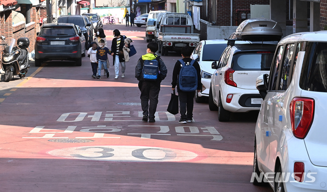 [수원=뉴시스] 김종택기자 = 민식이법 시행 1년을 하루 앞둔 24일 오후 경기도 수원시 팔달구 한 초등학교 앞 '어린이보호구역(스쿨존)'에 불법주차한 차량들이 줄지어 서 있다. 민식이법은 2019년 9월 충남 아산의 한 스쿨존에서 교통사고로 사망한 김민식군(당시 9세) 사고 이후 발의, 시행된 법안이다. 2021.03.24. jtk@newsis.com