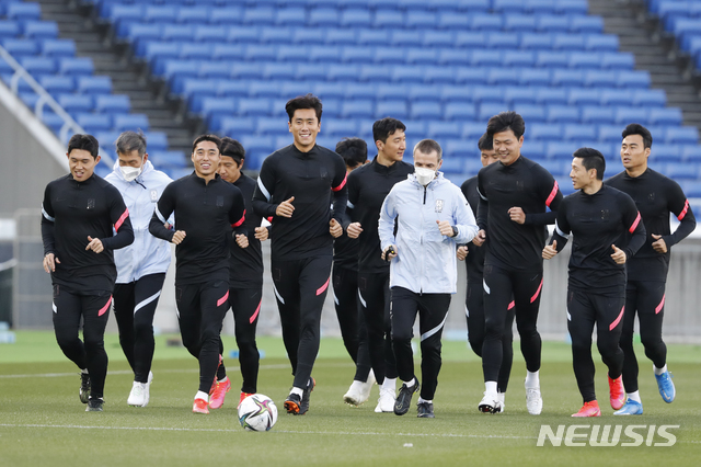 [요코하마=AP/뉴시스]한국 축구 국가대표 선수들이 24일 일본 도쿄 인근 요코하마의 닛산 스타디움에서 25일 열리는 일본 대표팀과의 친선경기를 앞두고 몸을 풀고 있다. 2021.03.24.