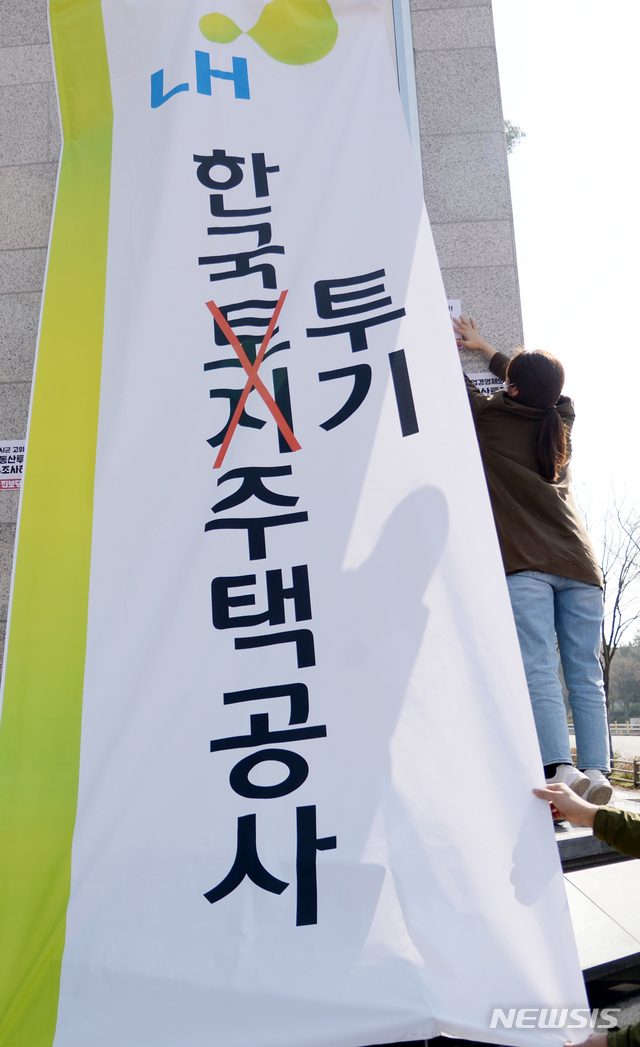 [전주=뉴시스] 김얼 기자 = 한국토지주택공사(LH) 전북본부 앞에서 'LH 해체 촉구 집회'를 열고 간판을 교체하는 퍼포먼스를 선보이고 있다. 2021.03.25. pmkeul@newsis.com