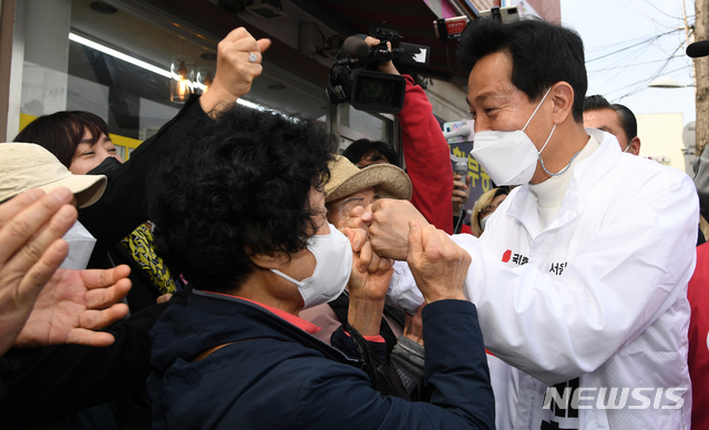 [서울=뉴시스]국회사진기자단 = 오세훈 국민의힘 서울시장 후보가 26일 오후 서울 용문시장 네거리에서 시민들과 주먹 인사를 하고 있다. 2021.03.26. photo@newsis.com