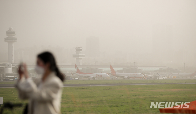 [제주=뉴시스]우장호 기자 = 황사경보가 발령되는 등 대기질이 악화한 29일 오후 제주국제공항 인근 올레길에서 바라본 제주시 도심이 뿌연 먼지로 덮여 있다. 황사경보는 1시간 평균 미세먼지(PM-10) 농도가 800㎍/㎥ 이상인 상태가 2시간이상 지속될 것으로 예상될 때 발령된다. 2021.03.29 woo1223@newsis.com