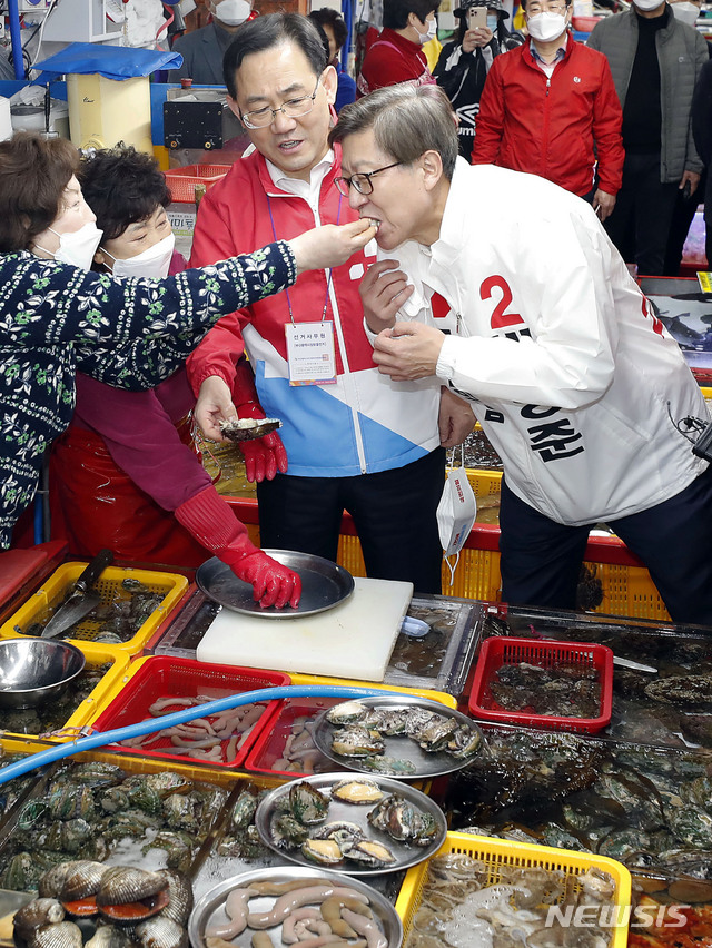 [부산=뉴시스]최동준 기자 = 국민의힘 박형준 부산시장 후보가 30일 주호영 원내대표와 부산 중구 자갈치시장을 방문해 회를 맛보고 있다. 2021.03.30. photocdj@newsis.com