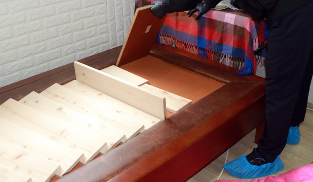 [부산=뉴시스] 숨겨둔 현금을 찾기 위해 돌침대를 분해하고 있는 경찰. (사진=부산경찰청 제공) *재판매 및 DB 금지