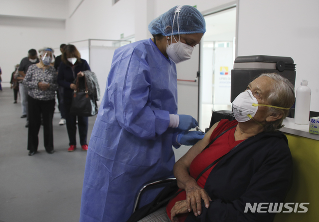 [키토=AP/뉴시스]3월 31일(현지시간) 에콰도르 수도 키토의 한 코로나19 백신 접종 센터에서 한 노인이 화이자 백신을 접종하고 있다. 2021.04.01.