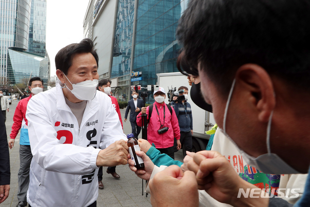 [서울=뉴시스]국회사진기자단 = 오세훈 국민의힘 서울시장 후보가 2일 오후 서울 마포구 상암DMC 거리에서 뚜벅이 순회인사를 하던 중 한 시민이 건넨 음료에 주먹인사를 하고 있다. 2021.04.02. photo@newsis.com