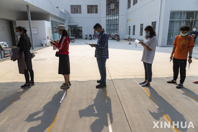 [루이리=신화/뉴시스] 중국 남부 윈난성 루이리에서 2일 마스크를 쓴 주민들이 코로나19 예방 접종을 받기 위해 순서를 기다리고 있다. 2021.04.03