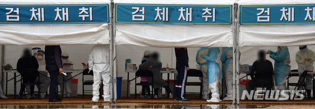 [부산=뉴시스] 하경민 기자 = 부산 사하구 신평레포츠공원에 설치된 코로나19 임시선별검사소를 찾은 시민들이 4일 오전 진단검사를 위한 검체를 채취하고 있다. 사하구는 최근 확진자가 급증하자 이 날부터 10일까지 임시선별검사소를 운영키로 했다. 2021.04.04. yulnetphoto@newsis.com