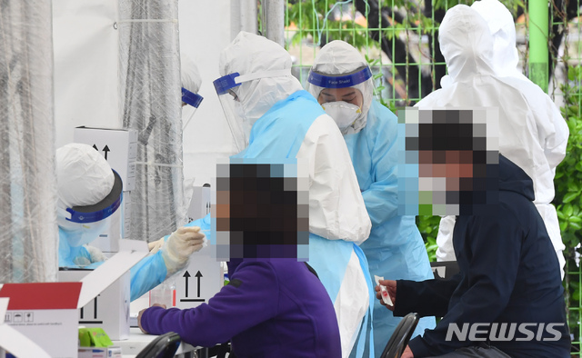 [부산=뉴시스] 하경민 기자 = 부산 사하구 신평레포츠공원에 설치된 코로나19 임시선별검사소를 찾은 시민들이 4일 오전 진단검사를 위한 검체를 채취하고 있다. 사하구는 최근 확진자가 급증하자 이 날부터 10일까지 임시선별검사소를 운영키로 했다. 2021.04.04. yulnetphoto@newsis.com