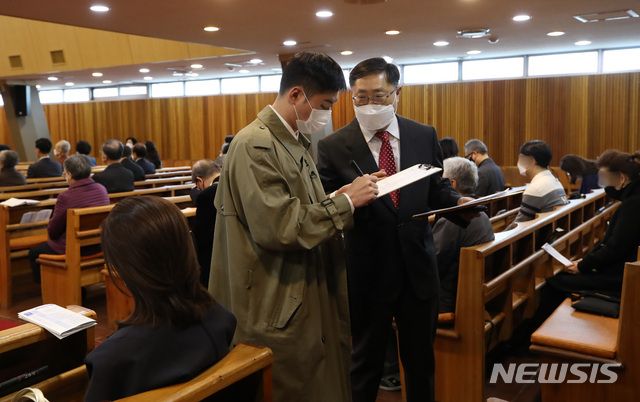 [서울=뉴시스]조수정 기자 = 4일 오전 서울 종로구 초동교회에서 열린 부활절 예배에서 서울시 방역 담당 직원과 교회 관계자가 코로나19 확산 예방을 위해 예배당 인원 및 방역사항 등을 확인하고 있다. 2021.04.04. chocrystal@newsis.com