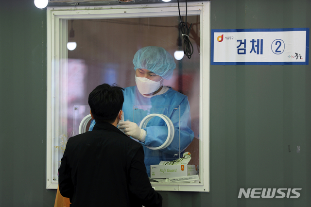 [서울=뉴시스]이윤청 기자 = 5일째 코로나19 신규 확진자가 500명대로 집계된 4일 서울 중구 서울역 광장 코로나19 중구 임시선별검사소에서 의료진이 검체를 채취하고 있다. 2021.04.04. radiohead@newsis.com