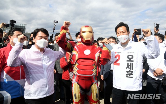[서울=뉴시스]국회사진기자단 = 오세훈 국민의힘 서울시장후보가 4일 서울 서초구 세빛섬 인근에서 안철수 공동선대위원장과 한강변 시민과 함께 걷기행사 중 아이언맨 복장의 참가자와 기념촬영을 하고있다. 2021.04.04. photo@newsis.com