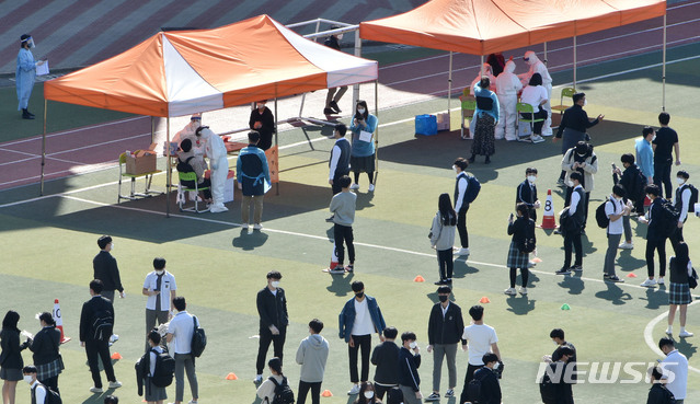 [대구=뉴시스] 이무열 기자 = 대구 수성구의 한 고등학교에서 코로나19 확진자가 발생한 6일 학생들이 진단검사를 받기 위해 운동장에 줄지어 차례를 기다리고 있다. 2021.04.06. lmy@newsis.com