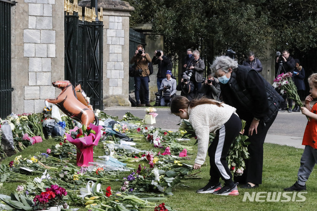 [윈저=AP/뉴시스]9일(현지시간) 영국 윈저성 정문 앞에서 시민들이 필립공을 기리기 위해 헌화하고 있다. 2021.4.9.