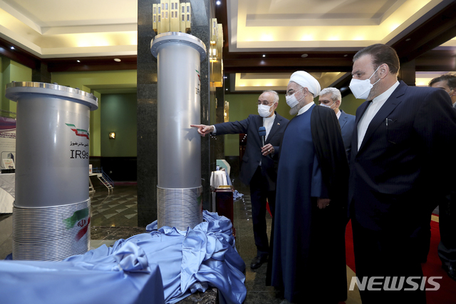 [테헤란=AP/뉴시스]하산 로하니 이란 대통령(오른쪽 두 번째)이 이란 '핵기술의 날'인 10일 테헤란에서 열린 이란의 새로운 핵 성과 전시회에 참석해 이란 원자력기구 관계자의 설명을 듣고 있다. 당사국의 '이란 핵합의'(JCPOA) 복원 회담이 진행 중인데도 불구하고 로하니 대통령은 이날 신형 핵 원심분리기 가동을 지시했다. 2021.04.10