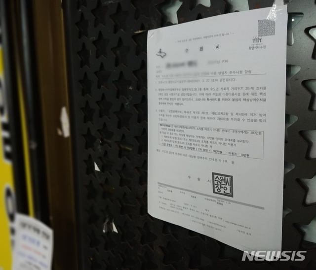 [수원=뉴시스] 안형철 기자= 12일 오후 8시께 경기 수원시 인계동의 유흥가 일대의 한 클럽 입구에 붙어있는 수원시청의 방역지침 안내문. 2020.04.12. goahc@newsis.com