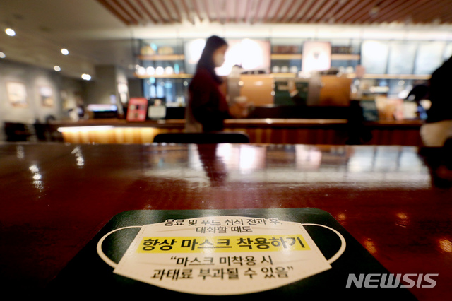 [서울=뉴시스]김병문 기자 = 사회적 거리두기 단계와 관계없이 모든 실내에서 마스크를 항상 착용해야하는 '마스크 착용 의무화 조치'가 시행된 12일 오후 서울 시내 카페에 마스크 착용이 안내돼 있다. 2021.04.12. dadazon@newsis.com