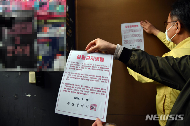 [부산=뉴시스] 하경민 기자 = 부산지역 유흥시설 집합금지 조치 첫날인 12일 오후 부산진구청 공무원들이 서면의 한 업소 출입구에 집합금지 행정명령문을 부착하고 있다. 부산시는 지난 2일부터 적용 중인 사회적 거리두기 2단계를 12일부터 5월 2일까지 3주간 연장하고, 특히 이 기간 유흥시설 5종과 홀덤펍에 대해서는 집합금지 명령을 내렸다. 2021.04.12. yulnetphoto@newsis.com