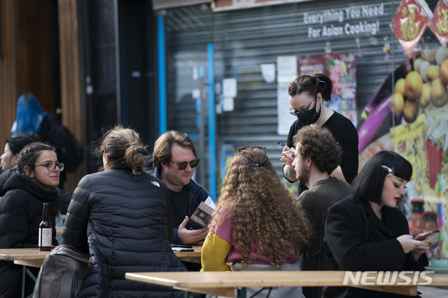[리버풀=AP/뉴시스]12일(현지시간) 영국 잉글랜드 리버풀의 한 음식점 밖에 손님들이 앉아 있다. 2021.4.12. 