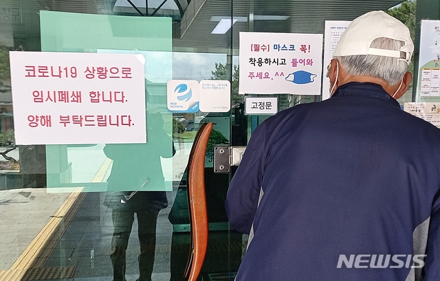 [괴산=뉴시스]강신욱 기자 = 충북 괴산군은 13일 코로나19 집단 감염이 발생한 지역의 한 교회 신도 공무원이 근무하는 괴산읍사무소를 임시 폐쇄했다. 이곳을 방문한 민원인이 출입문 앞에서 들어가지 못하고 있다. 2021.04.13. ksw64@newsis.com&nbsp; 