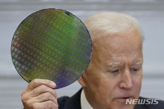 [워싱턴=AP/뉴시스]12일(현지시간) 미국 워싱턴 백악관 루즈벨트룸에서 열린 반도체 공급망 관련 회의에서 조 바이든 대통령이 반도체 웨이퍼를 들어보이고 있다. 2021.04.13. 
