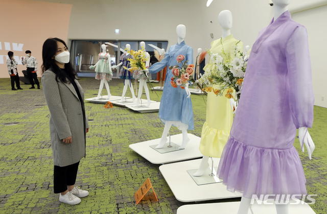 [서울=뉴시스]최진석 기자 = 13일 서울 중구 동대문디자인플라자(DDP)에서 열린 '케이팝X한복' 전시회를 찾은 관람객이 케이팝 스타들이 착용했던 한복을 둘러보고 있다. 문화체육관광부가 한복진흥센터와 함께 '2021 봄 한복문화주간'을 맞이해 열린 이번 전시회는 아이돌 그룹 등이 뮤직비디오와 무대, 광고 등에서 실제 입었던 한복이 전시됐다. 2021.04.13. myjs@newsis.com