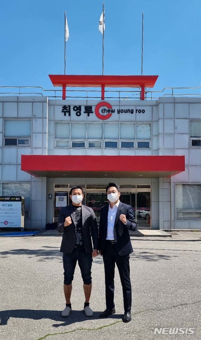 [서울=뉴시스]경기 파주시 공장 앞에서 포즈를 취한 '맨발의 사나이' 조승환(왼쪽)씨와 취영루 신정호 대표이사
