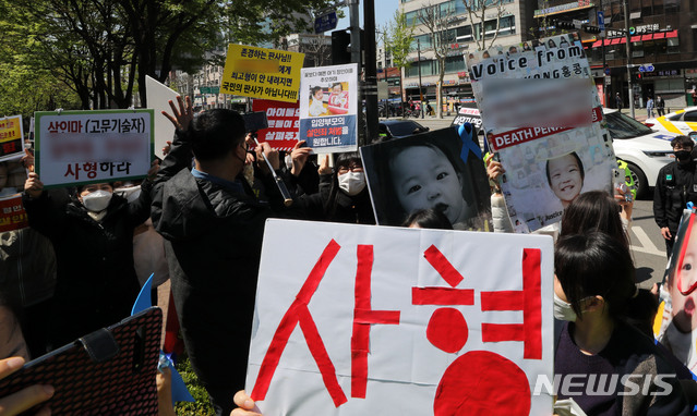 [서울=뉴시스]박주성 기자 = 양부모의 학대 끝에 숨진 16개월 된 입양 딸 '정인이'의 양부모의 결심 공판이 열린 14일 오후 서울 양천구 서울남부지방법원 입구에서 시민들이 양모가 탑승한 것으로 보이는 호송차를 향해 팻말을 들고 항의하고 있다. 2021.04.14. park7691@newsis.com