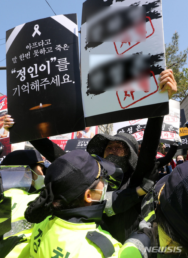 [서울=뉴시스]박주성 기자 = 양부모의 학대 끝에 숨진 16개월 된 입양 딸 '정인이'의 양부모의 결심 공판이 열린 지난 14일 오후 서울 양천구 서울남부지방법원 입구에서 시민들이 양모가 탑승한 것으로 보이는 호송차를 향해 손피켓을 들고 항의하고 있다. 2021.04.14. park7691@newsis.com