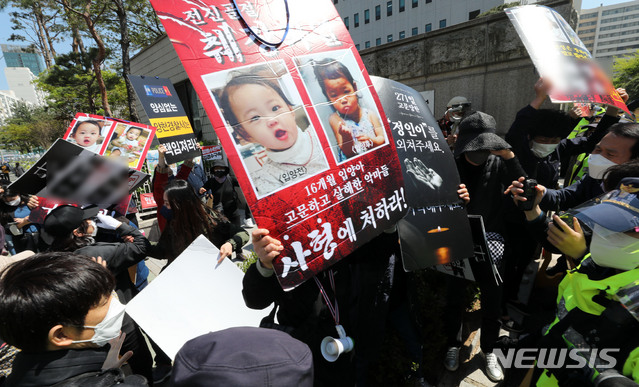 [서울=뉴시스]박주성 기자 = 양부모의 학대 끝에 숨진 16개월 된 입양 딸 '정인이'의 양부모의 결심 공판이 열린 14일 오후 서울 양천구 서울남부지방법원 입구에서 시민들이 양모가 탑승한 것으로 보이는 호송차를 향해 손피켓을 들고 항의하고 있다. 2021.04.14. park7691@newsis.com