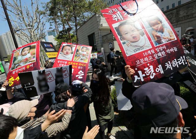 [서울=뉴시스]박주성 기자 = 양부모의 학대 끝에 숨진 것으로 조사된 16개월 된 입양 딸 '정인이'의 양부모 결심공판이 열린 지난달 14일 오후 서울 양천구 서울남부지법 입구에서 시민들이 양모가 탑승한 것으로 보이는 호송차를 향해 손피켓을 들고 항의하고 있다. 2021.04.14. park7691@newsis.com