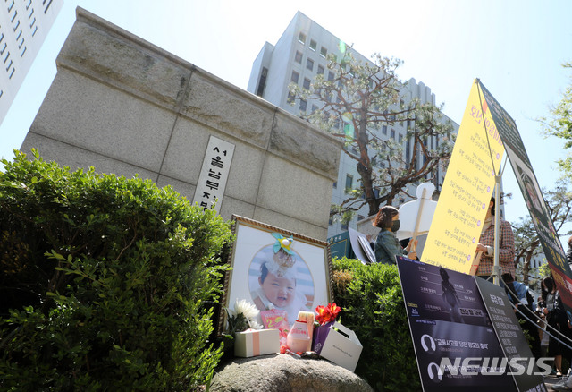 [서울=뉴시스]박주성 기자 = 양부모의 학대 끝에 숨진 16개월 된 입양 딸 '정인이'의 양부모의 결심 공판이 열린 지난 14일 오후 서울 양천구 서울남부지방법원 입구에 정인이의 사진이 놓여 있다. 2021.04.14. park7691@newsis.com