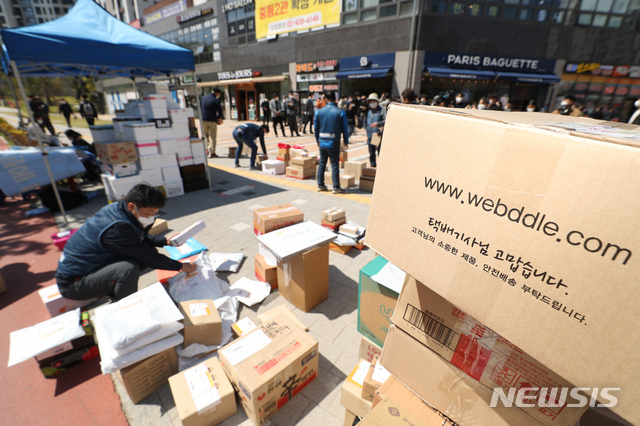 [서울=뉴시스]이윤청 기자 = 전국택배노동조합 조합원들이 지난 14일 서울 강동구 고덕동의 한 아파트단지 입구에 택배물품을 내린 후 분류 작업을 하고 있다. 총 5000세대 규모로 알려진 해당 아파트는 안전 사고 및 시설물 훼손 우려를 이유로 지난 1일부터 모든 차량이 지하주차장을 통해 이동하도록 했다. 하지만 대부분 택배차량은 지하주차장 진입제한 높이(2.3m)보다 차체가 높아 진입이 불가능하다. 2021.04.14. radiohead@newsis.com