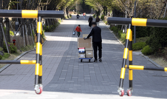 [서울=뉴시스] 최진석 기자 = 지난 15일 오후 서울 강동구 고덕동 한 아파트 단지 내로 택배 물품이 손수레에 실려 들어가고 있다. 해당 아파트는 지난 1일부터 단지 내 지상도로로 차량이 다니지 못하도록 전면 통제 됐으며, 지하 주차장 높이가 택배 차량의 높이보다 낮게 지어져 차량 출입이 불가능하다. 2021.04.15. myjs@newsis.com