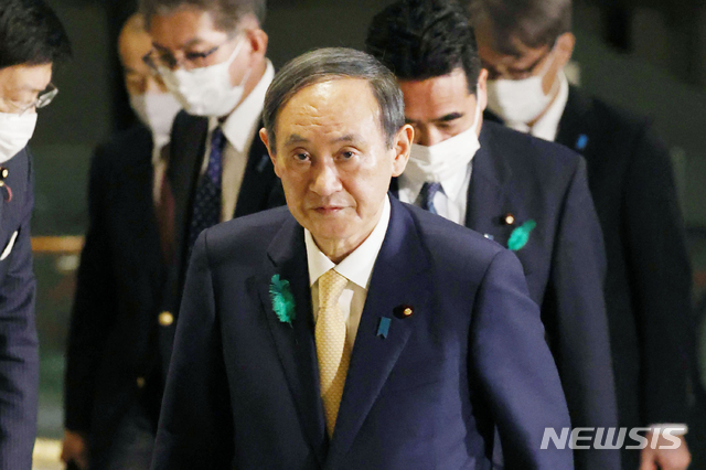 [도쿄=AP/뉴시스]지난 15일 밤 스가 요시히데 일본 총리가 공항으로 향하기 위해 총리 관저를 나서고 있다. 그는 이날 전용기로 미국 워싱턴을 향해 출발했다. 2021.04.16. 