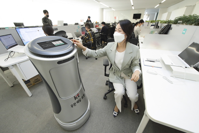 [서울=뉴시스]KT가 서울 KT 광화문 이스트 사옥에서 근무하고 있는 사내 임직원을 대상으로 ‘AI로봇 우편배송 서비스’를 시작했다고 18일 밝혔다. 직원들이 KT AI 로봇을 활용한 우편배송 서비스를 체험하고 있다. (사진=KT 제공) 2021.04.18. photo@newsis.com *재판매 및 DB 금지