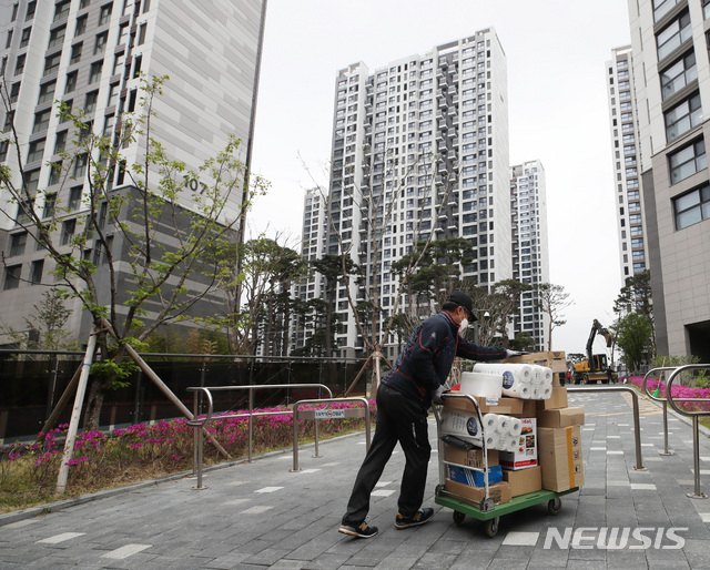 [서울=뉴시스]조수정 기자 = 전국택배노동조합이 지난 16일 오후 입주자대표회의가 배달차량 지상 진입을 전면 금지한 서울 강동구 고덕동의 한 아파트 단지 앞에서 기자회견을 마친 뒤 단지앞 배송을 철회하고 정상 개별배송을 시작, 한 택배노동자가 힘겹게 언덕을 오르고 있다. 노조는 이 아파트단지 일부 고객의 과도한 항의 문자와 전화로 심각한 정신적 피해를 호소하는 조합원을 보호하는 주동적 조치로 아파트단지 앞 배송을 일시 중단하고 정상 개별배송을 하기로 했다. 2021.04.16. chocrystal@newsis.com