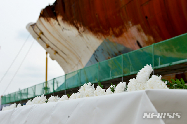 [목포=뉴시스]변재훈 기자 = 세월호 7주기인 16일 오후 전남 목포시 달동 목포신항만에 거치된 선체 앞에 희생자 유족들이 헌화한 국화가 놓여있다. 2021.04.16. wisdom21@newsis.com