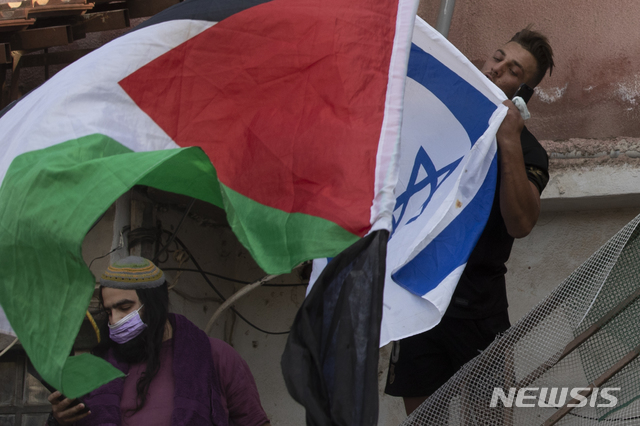 [예루살렘= AP/뉴시스] 예루살렘 구시가지에 있는 팔레스타인 사람들의 집이 4월 16일 이스라엘인들에게 강제로 점령당한 뒤 양쪽 시위대가 깃발을 들고 나와 대치하고 있는 모습.예루살렘에서는 라마단이 시작된 이후 팔레스타인인 집회를 막는 경찰과 시위대의 충돌이 매일 밤 벌어지고 있다.